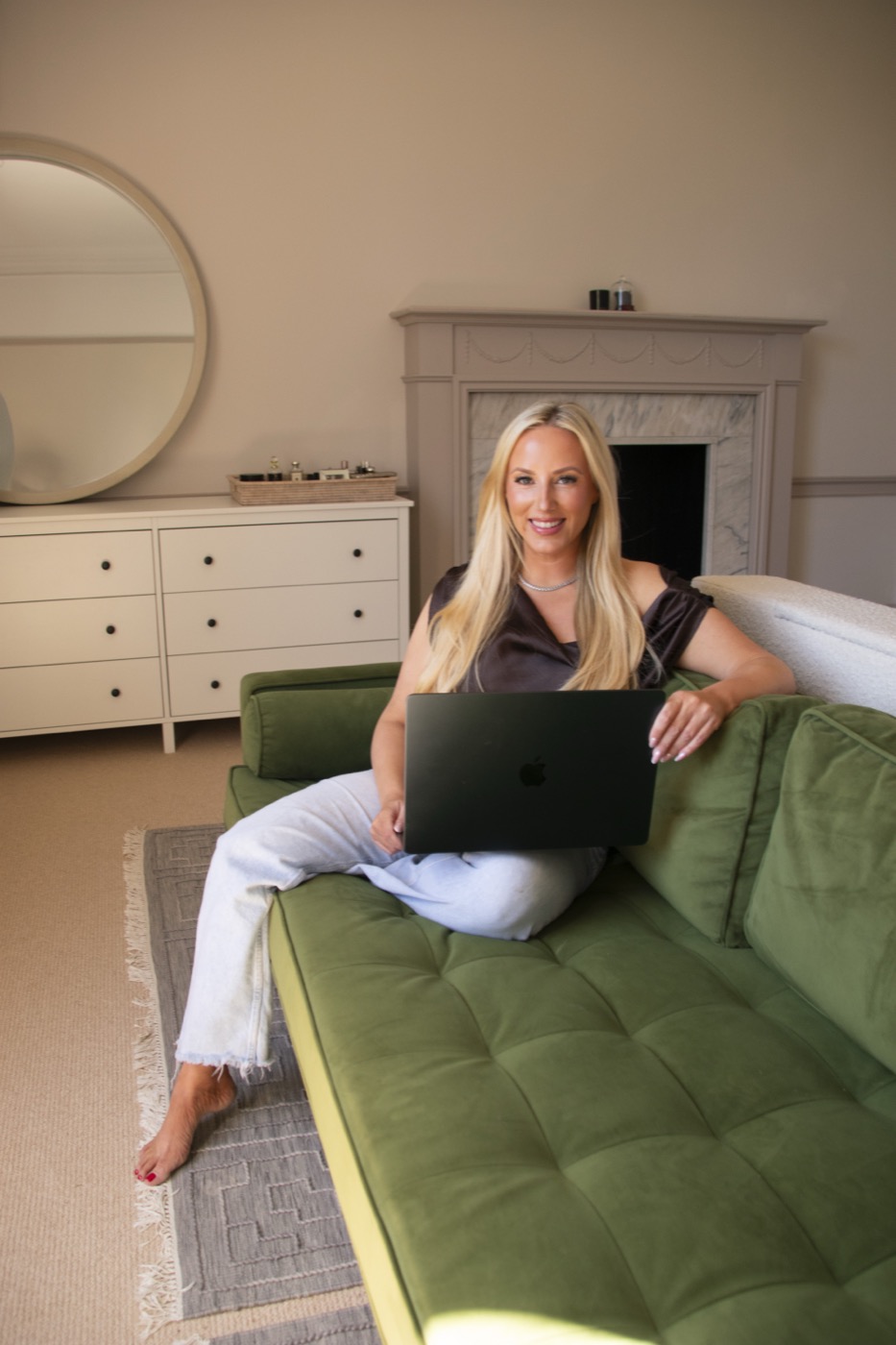 Kat Martyn, founder of Booked For You, working on her laptop in a warm-lit living room